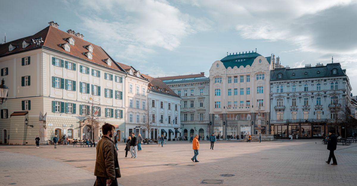 A bustling day in Bratislava's old town square with beautiful facades and pedestrians.